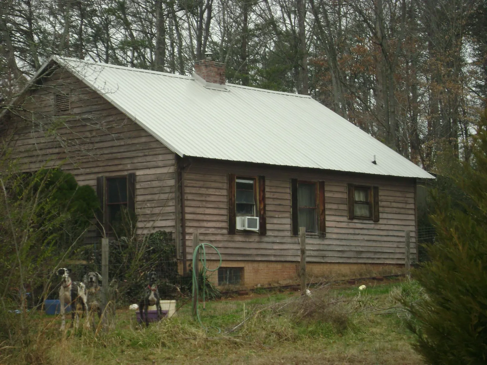 White metal roof on an old wood sided farmhouse, from a Metal Roof Installation job in Liberty